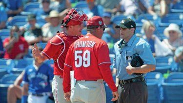 El receptor de los Filis de Filadelfia J.T. Realmuto y el manager Rob Thomson discuten con el árbitro Randy Rosenberg después de que el exjugador de Marlins de Miami fuera expulsado de un juego de béisbol de entrenamiento de primavera en Dunedin, Florida, el lunes 27 de marzo de 2023.&nbsp;