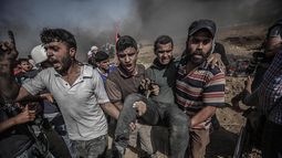 Palestinos llevan a un herido tras protestas este 8 de junio cerca de la Franja de Gaza. 