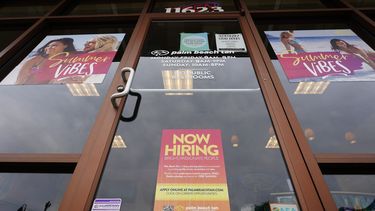 Letrero en la puerta de un negocio que busca empleados.