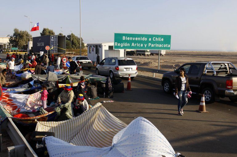 Migrantes venezolanos en la frontera esperan para entrar a Chile. 