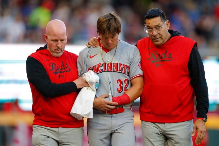 Tyler Callihan #32 de los Cincinnati Reds recibe ayuda para salir del campo tras chocar contra la barda durante la tercera entrada contra los Atlanta Braves en el Truist Park el 5 de mayo de 2025 en Atlanta, Georgia.&nbsp;