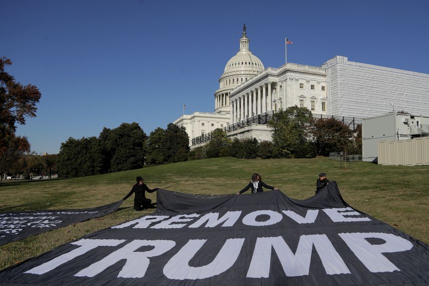 Manifestantes extienden grandes mantas sobre el jard&iacute;n adyacente al Congreso, Washington, durante una audiencia que investiga al presidente Donald Trump, 13 de noviembre de 2019. El texto dice destituyan a Trump.&nbsp;