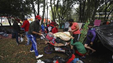 Migrantes venezolanos desempleados y sin hogar organizan sus pertenencias en un parque cerca de la principal terminal de autobuses en Bogot&aacute;, Colombia, el mi&eacute;rcoles 3 de junio de 2020. Frente a las restricciones de viaje y sin trabajo debido al cierre econ&oacute;mico para frenar el COVID-19, los migrantes venezolanos acampan en el lugar mientras esperan ayuda para volver a su pa&iacute;s.