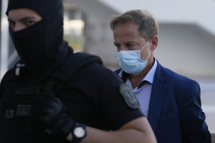 El exdirector artístico del Teatro Nacional de Grecia, Dimitris Lignadis, llega escoltado por la policía a un tribunal en Atenas el miércoles 13 de julio de 2022.