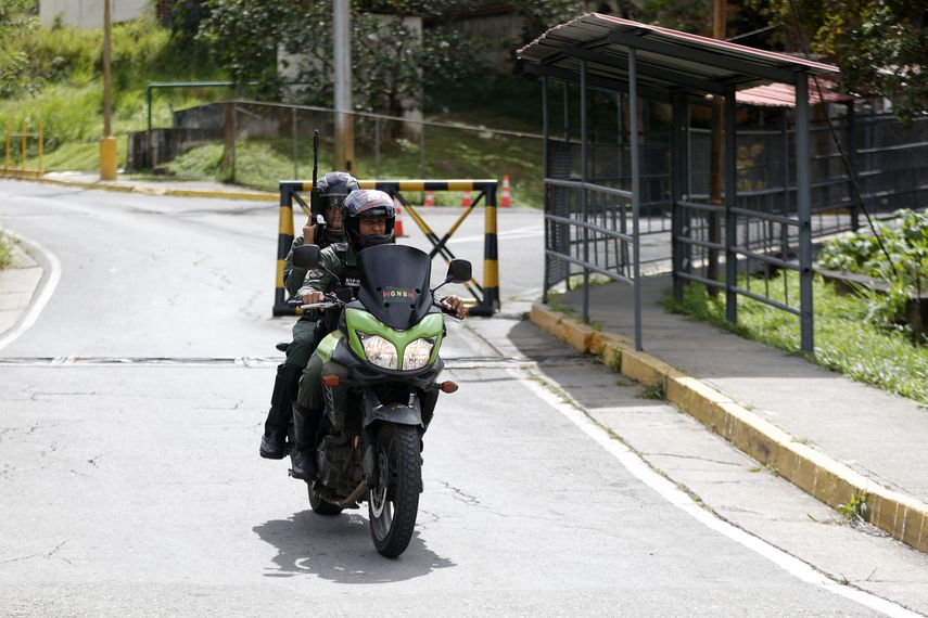 Dos funcionarios policiales van en moto saliendo de un centro penitenciario en Venezuela
