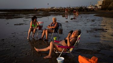 Ante la ola de calor en España, personas toman el sol en una playa en Chipiona, ubicado en la costa del Atlántico, en la provincia Cadiz.
