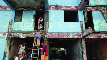 Cubanos en Baracoa revisan los destrozos dejados por el paso del huracán Matthew.