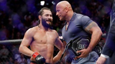 Jorge Masvidal (izquierda) recibe el cinturón BMF de parte del actor Dwayne The Rock Johnson, el 3 de noviembre de 2019.