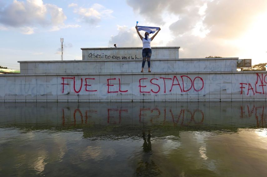 Un manifestante enmascarado alza una bandera durante una protesta contra el gobierno del presidente Daniel Ortega en Managua, Nicaragua. Se han presentado 18 testigos que dicen haber sufrido torturas y abuso sexual a manos de las fuerzas represivas, ante un panel de abogados y psic&oacute;logos en San Jos&eacute;, Costa Rica, la semana del 11 de septiembre de 2020. Foto de archivo del 1 de junio de 2020.
