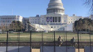 Dos miembros de la Guardia Nacional vigilan el domingo 10 de enero de 2021 detrás de una reja que rodea al Capitolio, en Washington.