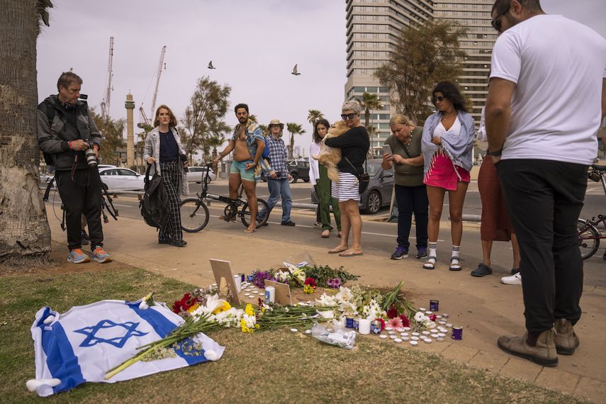 Un grupo de personas se congrega y coloca flores en el lugar donde murió el turista italiano Alessandro Parini en un ataque palestino, en Tel Aviv, Israel, el sábado 8 de abril de 2023.&nbsp;