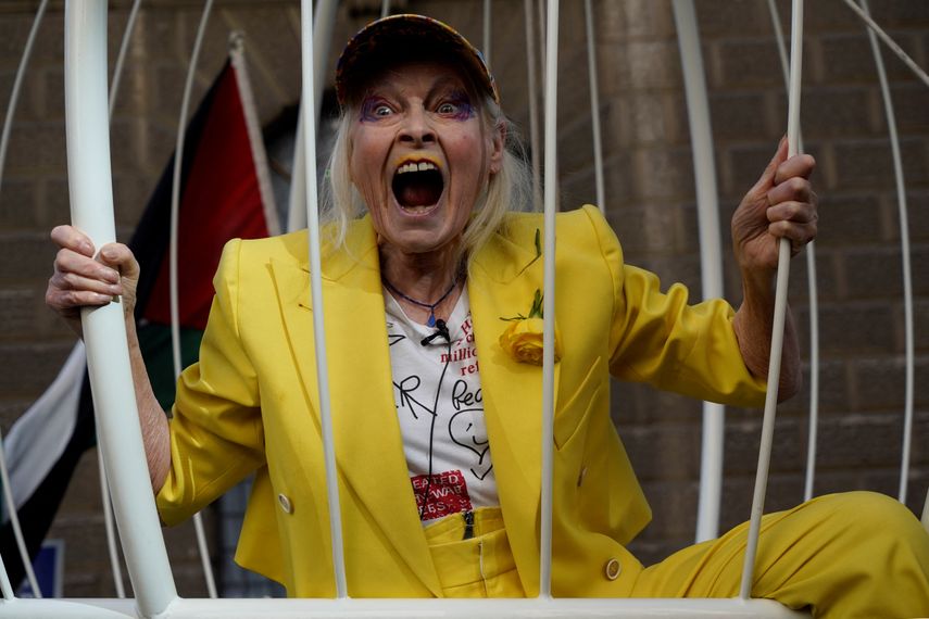En esta foto de archivo tomada el 21 de julio de 2020, la diseñadora británica Vivienne Westwood gesticula desde el interior de una jaula de pájaros gigante, suspendida del suelo, frente a Old Bailey en el centro de Londres, en protesta por el juicio de extradición del fundador de Wikileaks, Julian Assange.
