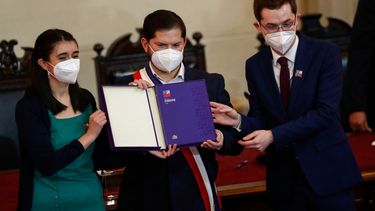 El presidente chileno, Gabriel Boric (C), sostiene el borrador final de la propuesta constitucional junto a la presidenta y vicepresidenta de la Convención Constituyente de Chile, María Elisa Quinteros (L) y Gaspar Domínguez (R), respectivamente, durante su presentación en el Congreso Nacional en Santiago, Chile, a 4 de julio de 2022.&nbsp;