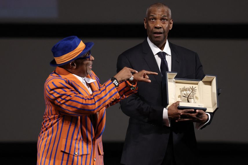 El actor estadounidense Denzel Washington recibe la Palma de Oro Honorífica de manos del director y productor ejecutivo estadounidense Spike Lee antes de la proyección de la película Highest 2 Lowest en la 78.ª edición del Festival de Cine de Cannes, en Cannes, sur de Francia, el 19 de mayo de 2025.