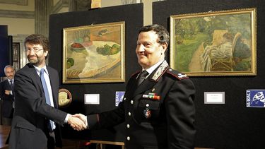 El ministro de cultural italiano, Dario Franceschini (izda), y el brigadier general de cultura de los Carabinieri, Mariano Mossa (dcha) posan con las pinturas. (EFE)