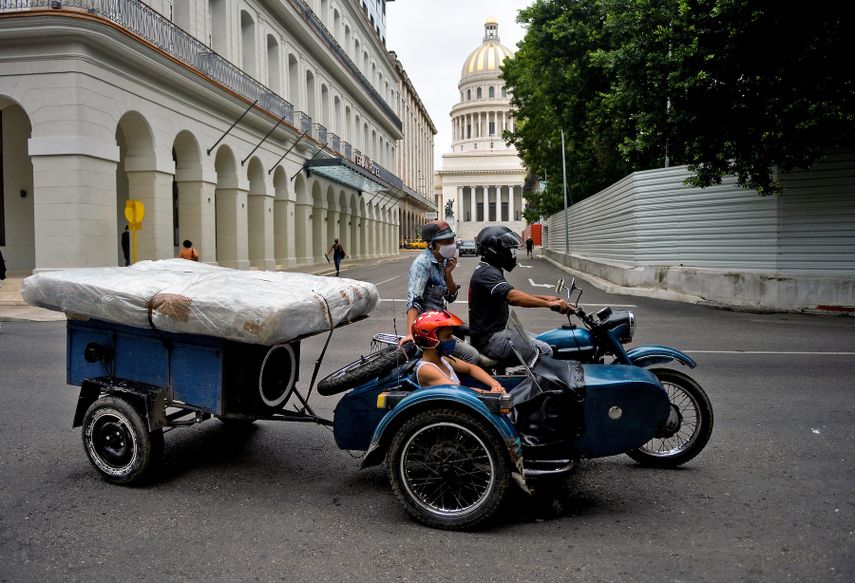 Una familia a bordo de una motocicleta con sidecar transporta un colchón en un carrito en La Habana, el 2 de diciembre de 2020.