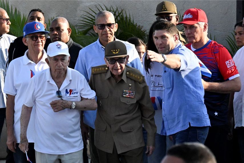 El dictador Raúl Castro (centro vestido de verde olivo) y el exvicepresidente José Ramón Machado Ventura (izquierda) asisten a un mitin del Primero de Mayo en La Habana para conmemorar el Día Internacional de los Trabajadores el 1 de mayo de 2026. El nieto de Raúl Castro, Raúl Guillermo Rodríguez Castro, les indica con la mano derecha hacia dónde deben drigirse.