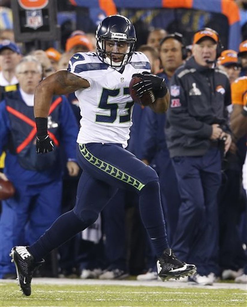 Malcolm Smith de los Seahawks de Seattle se enfila para anotar un touchodown tras un pase interceptado durante el primer tiempo del Super Bowl. (AP)