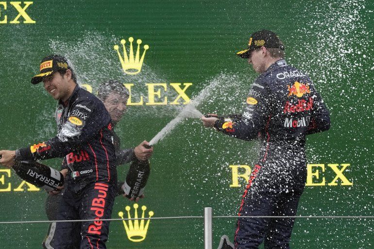 Los pilotos de Red Bull, Max Verstappen (derecha) y Sergio Pérez celebran en el podio luego de ganar el 1er y 2do lugar respectivamente en el Gran Premio de Emilia Romaña, el domingo 24 de abril de 2022, en Imola, Italia. 