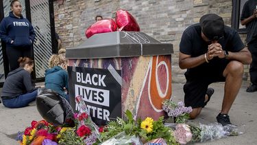 Varias personas se re&uacute;nen alrededor de un memorial improvisado&nbsp;para honrar a George Floyd, el hombre afroestadounidense que muri&oacute; asfixiado durante una operaci&oacute;n de arresto policial en Minneapolis.