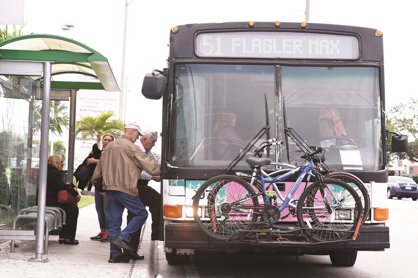 Varios pasajeros abordan un ómnibus del servicio de transporte público de Miami.