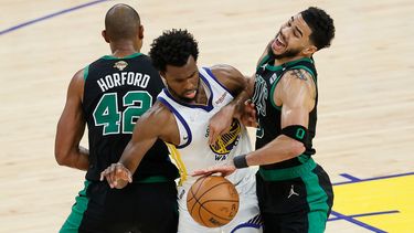 Andrew Wiggins, al centro, de los Warriors de Golden State se queda con el balón al pasar entre Al Horford (42) y Jayson Tatum de los Celtics de Boston en el quinto partido de las finales de la NBA, el lunes 13 de junio de 2022, en San Francisco.&nbsp;