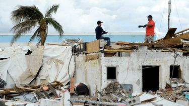 Dos personas trabajan encima de una construcción que resultó sumamente dañada por el huracán Ian, el domingo 9 de octubre de 2022, en Fort Myers Beach, Florida. 