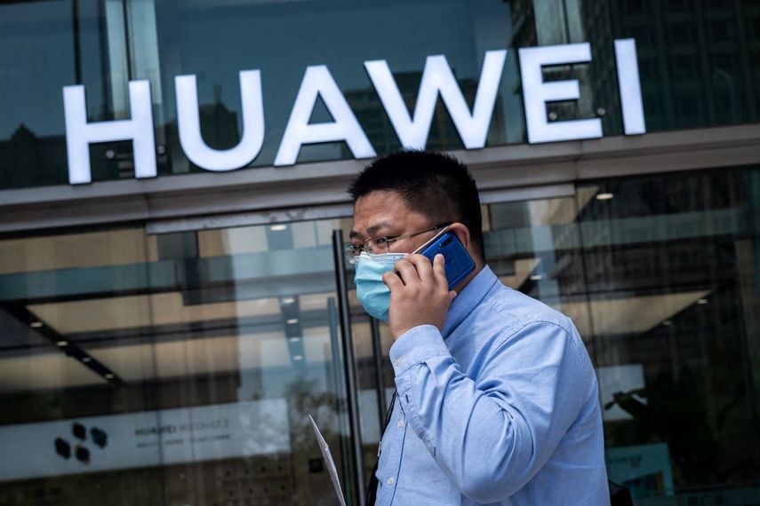 Un hombre pasa frente al logo del gigante chino de la telefonía Huawei.