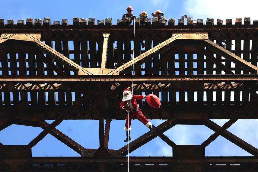 El bombero Héctor Chacón Cuellar, vestido de Santa Claus, desciende sobre el asentamiento Jesús de la Buena Esperanza, en Ciudad de Guatemala.&nbsp;