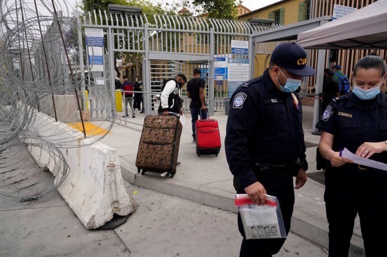 El hondureño Alex Cortillo (izq) y su medio hermano se aprestan a cruzar la frontera desde Tijuana (México) para solicitar asilo en EEUU.
