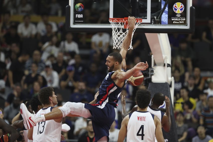 El pivot franc&eacute;s Rudy Gobert, centro, clava el bal&oacute;n ante la mirada de los estadounidenses Brook Lopez, izquierda, y Derrick White en el partido de cuartos de final de la Copa del Mundo de la FIBA en Dongguan, China, el mi&eacute;rcoles 11 de septiembre de 2019. Francia venci&oacute; 89-79 a Estados Unidos.