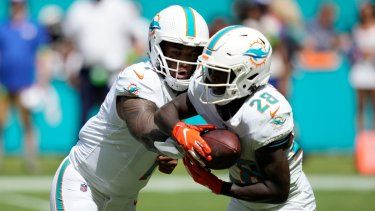 El mariscal de campo de los Miami Dolphins, Tua Tagovailoa (1), le entrega el balón al corredor DeVon Achane (28) durante la primera mitad de un partido de fútbol americano de la NFL contra los New York Giants, el domingo 8 de octubre de 2023, en Miami Gardens, Florida.&nbsp;