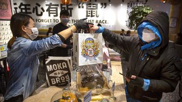 &nbsp; El gerente Chen Tiantian, izquierda, entrega una orden a un repartidor en la cafeter&iacute;a Moka Bros de Beijing, el viernes 14 de febrero de 2020. Como muchos negocios en China, Moka Bros pasa apuros para enfrentar las secuelas del brote de coronavirus que ha infectado a decenas de miles de personas en el mundo.&nbsp;