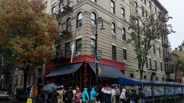 Fanáticos hacen fila para rendir homenaje al actor Matthew Perry afuera del edificio de apartamentos que se usó como toma exterior en el programa de televisión Friends en Nueva York el 29 de octubre de 2023.
