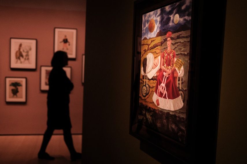 La pintura Árbol de la esperanza, mantente firme, de Frida Kahlo, se exhibe mientras una mujer observa las obras de arte durante una presentación a la prensa de la exposición Frida y Diego: El último sueño en el Museo de Arte Moderno (MoMA) de Nueva York.