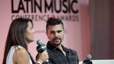 Juanes escucha una pregunta de la presentadora Ingrid Otero durante una sesión de preguntas y respuestas en la Conferencia Billboard de la Música Latina. (AP)