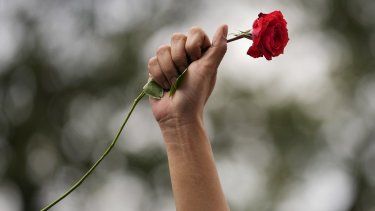 Una manifestante levanta el puño al aire con una rosa roja durante una protesta en Manila, Filipinas, con motivo del Día Internacional de la Mujer, el 8 de marzo de 2023.