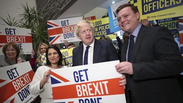 La secretaria brit&aacute;nica de Interior, Priti Patel, en el centro izquierda, el primer ministro brit&aacute;nico, Boris Johnson, en el centro, y el parlamentario Will Quince, posan sosteniendo un cartel antes un mitin, dentro de la campa&ntilde;a para las elecciones generales, en Colchester, Inglaterra, el lunes 2 de diciembre de 2019.&nbsp;