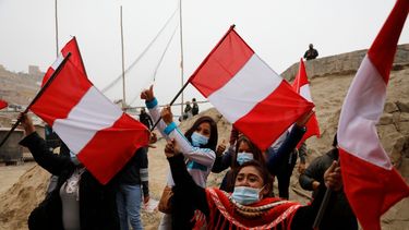 Los partidarios de la candidata presidencial Keiko Fujimori ondean banderas peruanas esperando su llegada a un desayuno en el barrio de San Juan de Lurigancho en Lima, Perú, el domingo 6 de junio de 2021