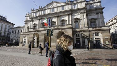 En esta fotograf&iacute;a del 24 de febrero de 2020 una mujer con una m&aacute;scara sanitaria pasa frente a la &oacute;pera La Scala en Mil&aacute;n, Italia.&nbsp; 