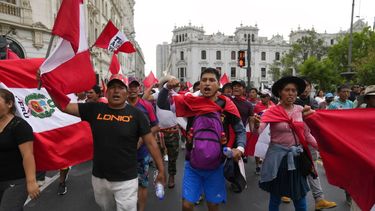 Manifestantes que viajaron a la capital desde otras partes del país se enfrentan a una línea de policías antimotines en una marcha contra la presidenta peruana Dina Boluarte en Lima, Perú.