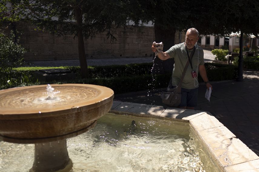 Un hombre sumerge su sombrero en una fuente para refrescarse en Ronda, en el sur de España, durante la primera ola de calor del verano, el 2 de julio de 2025.