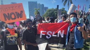 Activistas del Frente Sandinista participando en las protestas en Miami, con la bandera del partido de la dictadura de Daniel Ortega.