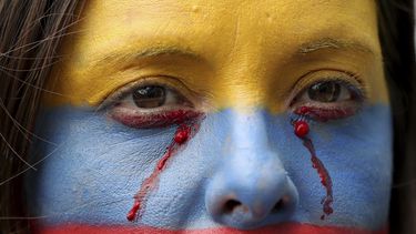 Fotograf&iacute;a del 27 de noviembre de 2019 de una mujer con el rostro pintado con los colores de la bandera de Colombia.