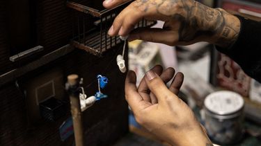 Danny Cortés, un artista callejero de miniaturas, trabaja en una nueva miniatura en su estudio en el distrito de Brooklyn de la ciudad de Nueva York el 19 de diciembre de 2022. &nbsp;