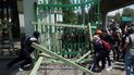 Manifestantes que protestan por la desaparición de 43 estudiantes universitarios retiran las puertas y barreras de una base militar en la Ciudad de México, el viernes 23 de septiembre de 2022