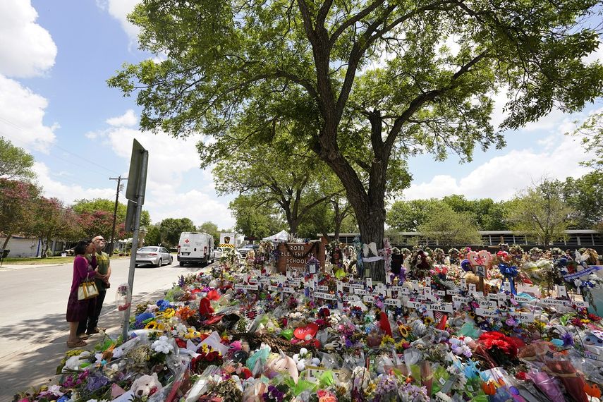 Nogales plantados en la década de 1960 cubren con su sombra un monumento conmemorativo improvisado en honor de las víctimas de la reciente masacre en la Escuela Primaria Robb, el jueves 9 de junio de 2022, en Uvalde, Texas.&nbsp;