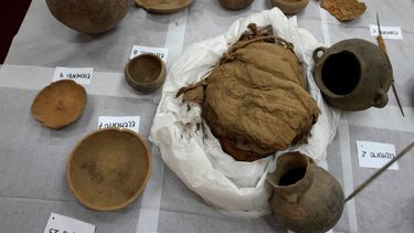 Momias infantiles aparentemente sacrificadas para acompañar a un noble muerto al más allá y vasijas descubiertas recientemente por arqueólogos que trabajan en la segunda ciudad preincaica más grande de Perú se exhiben para una presentación ante los medios en la Universidad de San Marcos, en Lima, el martes 22 de febrero de 2022.