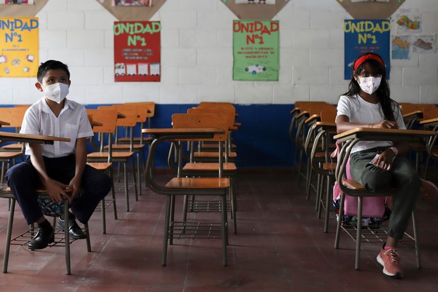 Estudiantes mantienen distancia social el primer día de regreso a la escuela presencial, en Antiguo Cuzcatlan, El Salvador, el martes 6 de abril de 2021. El Salvador reabrió sus escuelas el martes para el aprendizaje en persona más de un año después del cierre debido a la pandemia de coronavirus.