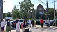 Residentes frente a la iglesia católica donde murieron 2 niños y otros 14 se encuentran heridos tras el mortal ataque de un genocida.
